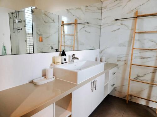 墨尔本Hillcrest Harmony: Luxury in Westmeadows 20% OFF的白色的浴室设有水槽和镜子