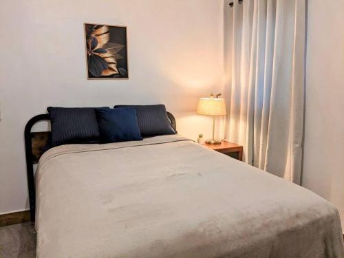 圣何塞德尔卡沃Estudio Bengala的一间卧室配有一张床和一张带台灯的桌子