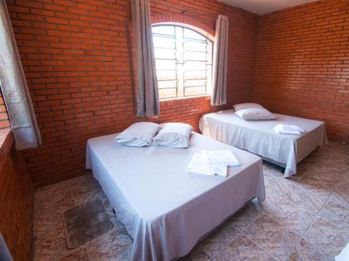 卡内拉Residencial Colling的砖墙客房的两张床