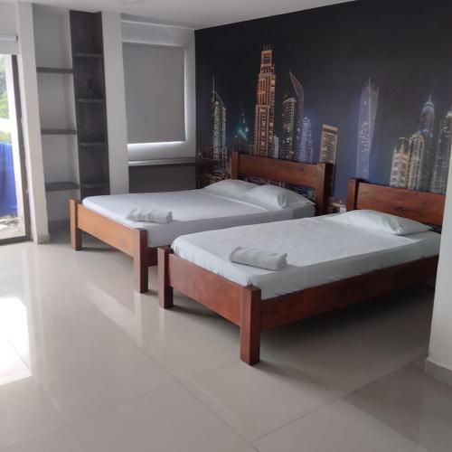 卡利Apartahotel APR的卧室内的两张床,墙上挂有城市壁画