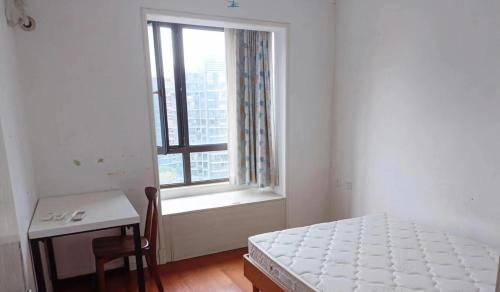 上海新虹桥首府的一间卧室配有一张床、一张桌子和一个窗户。