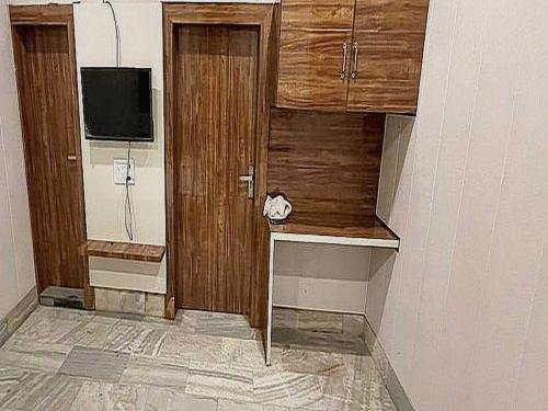 希萨尔OYO Bishnoi Hotel的客房设有木制橱柜和平面电视。