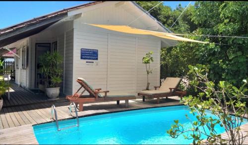 坎布里Canto Boreal - Suítes e Estúdios的一座带两个长椅和游泳池的房子