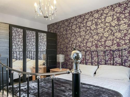 伊肯斯顿Royal House的一间卧室配有床和壁纸覆盖的墙壁