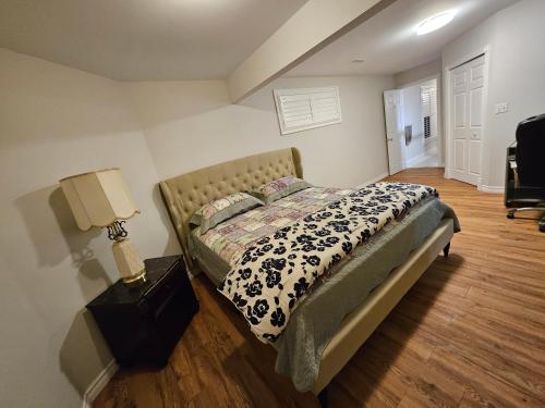 北湾Oakridge的一间卧室配有一张床和一张桌子上的台灯