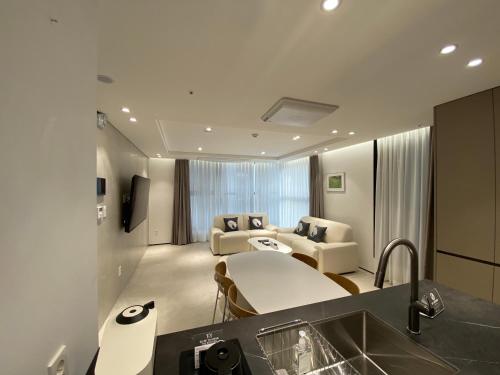 首尔HOTEL THE DESIGNERS LYJ SUITE YEOKSAM的厨房以及带沙发和水槽的起居室。