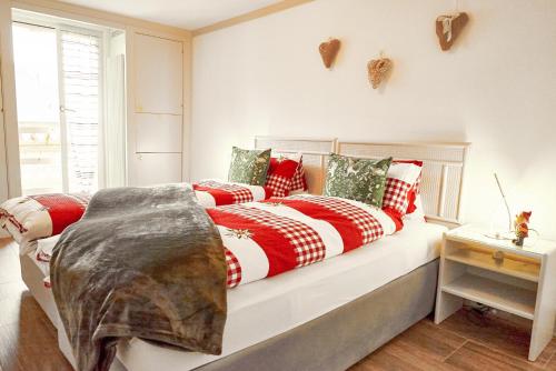 DärligenSweet Room by Interlaken的一张带红白毯子和枕头的床