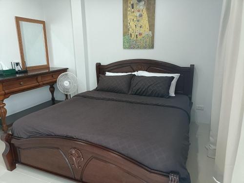 素叻88house suratthani的一间卧室配有一张带书桌和镜子的床