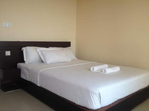 KelātaliWorld Beach Resort的一张白色的大床,带两条毛巾