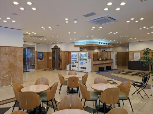 函馆Toyoko Inn Hokkaido Hakodate Ekimae Daimon的一个带桌椅的自助餐厅和一个厨房