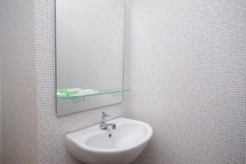 梭罗RedDoorz Apartment near Exit Toll Colomadu的白色的浴室设有水槽和镜子