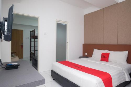 梭罗RedDoorz Apartment near Exit Toll Colomadu的卧室配有带红色枕头的大型白色床