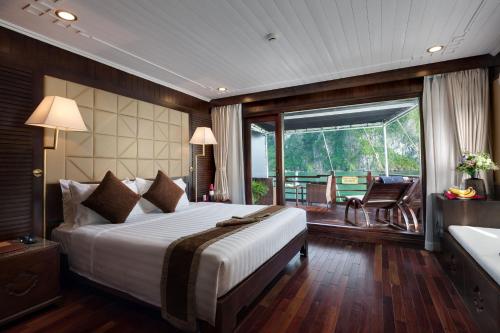 下龙湾Mila Cruises的一间带大床的卧室和一个阳台