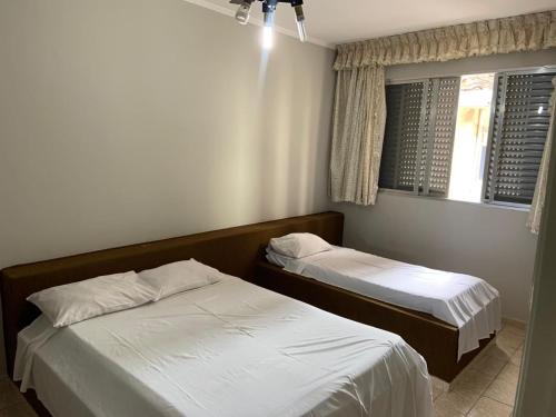 大普拉亚Casa Gomes的一间卧室设有两张床和窗户。