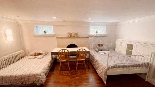 多伦多Cozy Home near Eglinton west Station Toronto!的一间设有两张床和一张桌子及椅子的房间