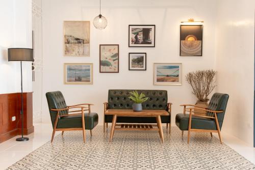 蔻立Bania Boutique House的客厅配有沙发、两把椅子和一张桌子