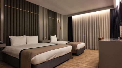 埃尔祖鲁姆Lala Grand Hotel的酒店客房配有两张床和一张书桌