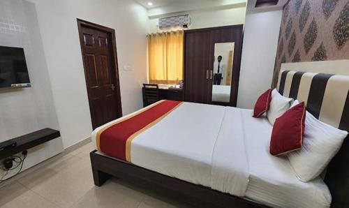 班加罗尔FabHotel Panchami Comforts的一间卧室配有一张大床和电视