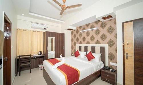 班加罗尔FabHotel Panchami Comforts的一间卧室配有一张大床和一张书桌
