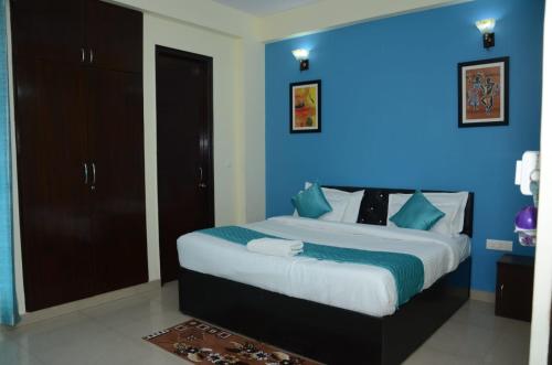 诺伊达Rumaisa Red的一间卧室设有一张蓝色墙壁的大床