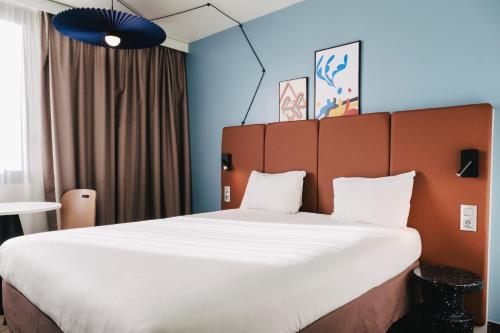 鲁昂坎帕尼尔罗恩梅尔莫兹旅馆的一张大床,位于一个白色的大床上