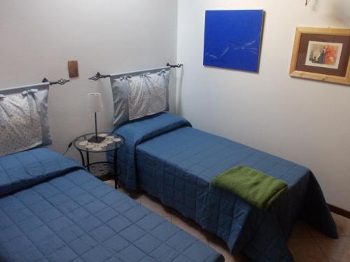 阿斯科利皮切诺Dimora Giosafatti的一间卧室配有两张床和一张带台灯的桌子