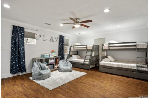 圣安东尼奥Experience Serenity in a 4BR3BA Downtown Home的客房设有两张双层床和吊扇。