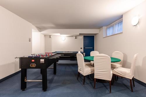 迪马罗Hotel garni Meledrio的配有乒乓球桌和椅子的房间