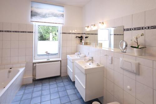 瓦尔内明德Haus der kurzen Wege的白色的浴室设有水槽和浴缸。