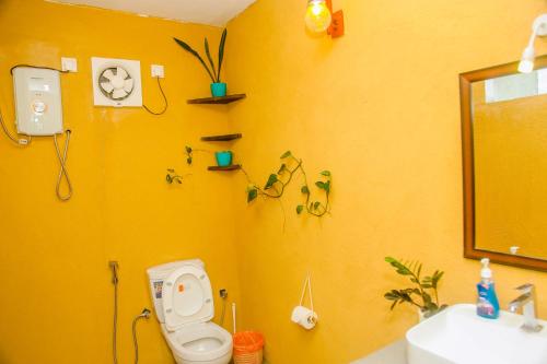 米瑞莎Feeling tip'sea rooftop villa的黄色的浴室设有卫生间和水槽