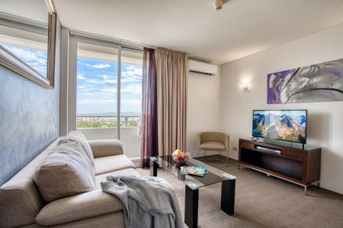 悉尼雷吉斯公园礼宾公寓的带沙发和平面电视的客厅