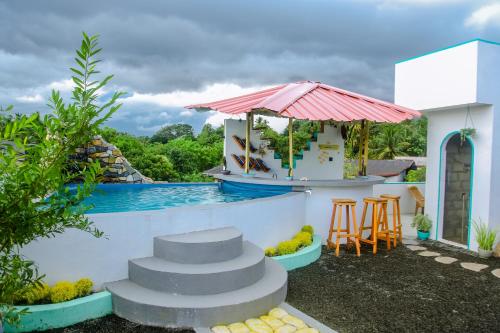 米瑞莎Feeling tip'sea rooftop villa的一个带游泳池和带凳子的酒吧的度假胜地