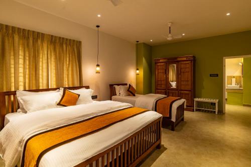 蒙纳Makayiram Retreat的酒店客房,设有两张床和镜子
