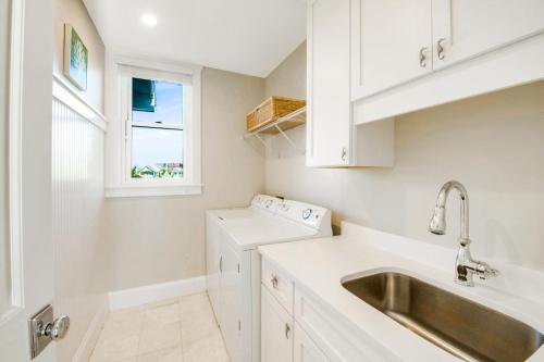 布雷登顿海滩Tropical Hideaway的白色的厨房设有水槽和窗户