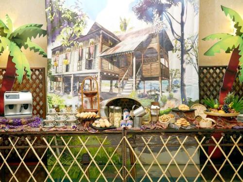 波德申Le Seaview PortDickson的一张桌子,上面有食物和房子的壁画