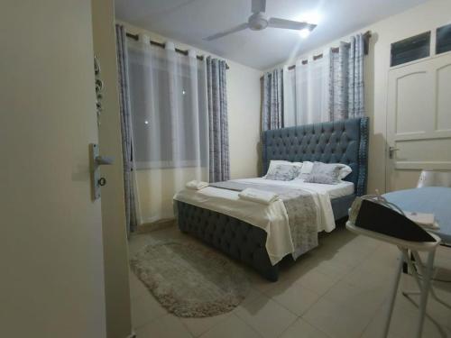 蒙巴萨Joly Apartments, Nyali Mombasa的一间卧室设有蓝色的床和窗户。