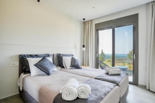 马斯蒂查里Aegean Sunset Villas的一间卧室设有两张床和大窗户