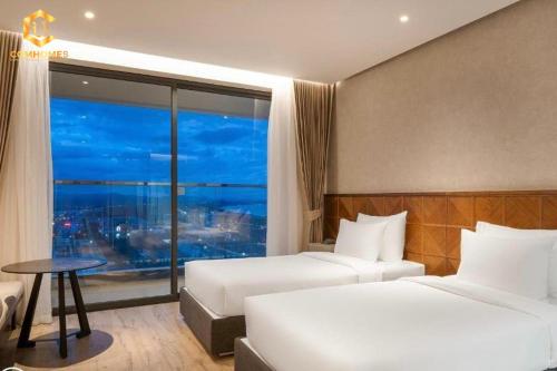 绥和市Apec Mandala Condotel Sea View Comhomes Phú Yên的酒店客房设有两张床和窗户。