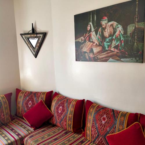 塞拉Belle appartement的客厅配有沙发和墙上的绘画
