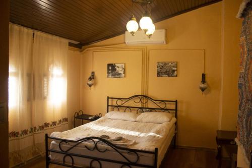 加济安泰普Şirvani Konağı的一间卧室配有一张床和一个吊灯