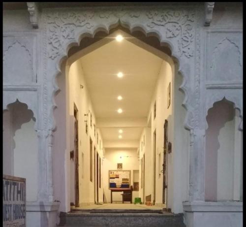 布什格尔Pushkar Guest House的楼里的拱门,有桌子在远处