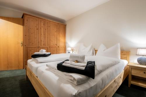 巴德加斯坦Bergblick Appartements的卧室配有带毛巾的大型白色床