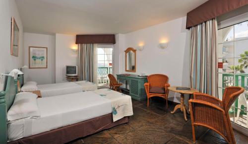 拉海瑞德拉首尔洛斯芬尼西斯酒店的酒店客房,配有一张床、一张桌子和椅子