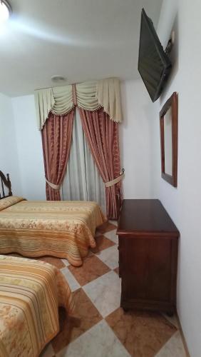 Villanueva de AlgaidasHostal Algaidas的酒店客房设有两张床和电视。