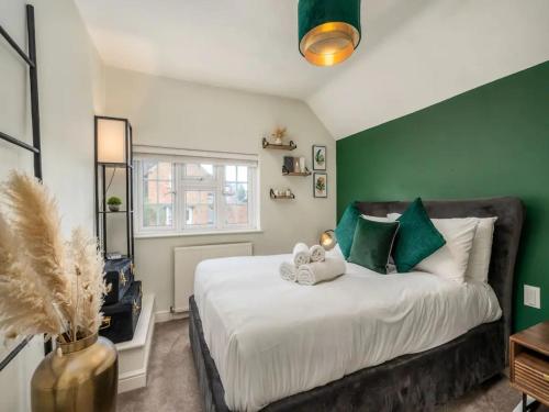 里克曼斯沃斯Pass the Keys Stylish Modern 3 bed house with Parking的一间卧室设有一张带绿色墙壁的大床