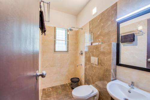 蓬蒂切里Iyla Apart Hotel的带淋浴、卫生间和盥洗盆的浴室