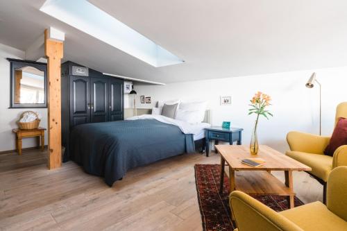 蒂罗尔-泽费尔德HENRI Country House Seefeld的一间卧室设有一张床和一间客厅。