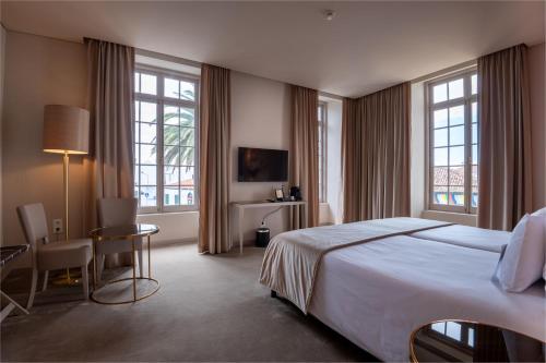 蓬塔德尔加达Vila Gale Collection S.Miguel的酒店客房设有一张床、一张书桌和窗户。