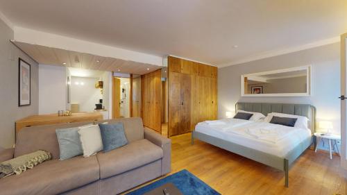 圣莫里茨Abitaziun Residence 10A - St Moritz的一间卧室配有一张床和一张沙发