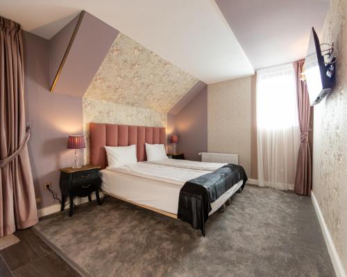 波亚纳布拉索夫Torres Poiana的一间卧室设有一张大床和一个窗户。